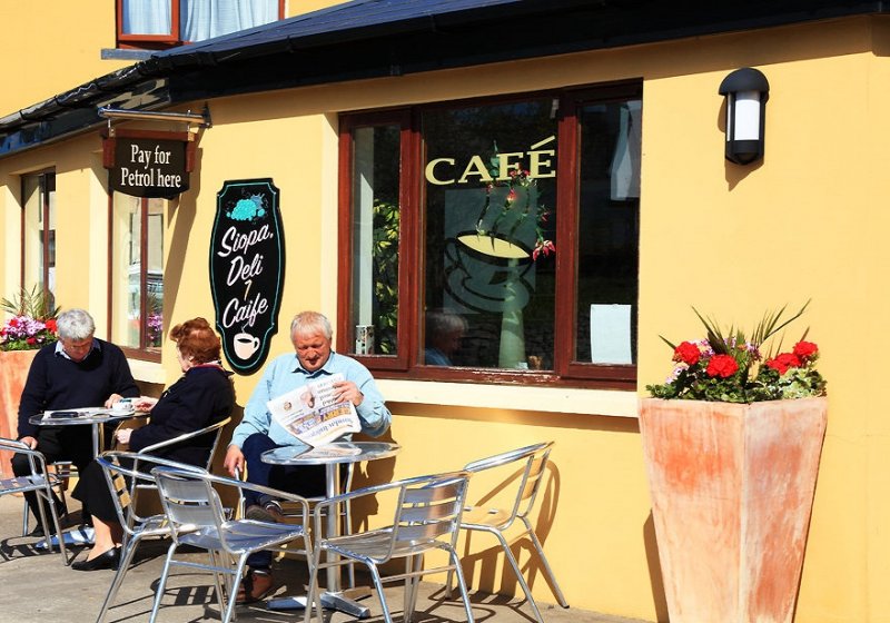 A man reads a newspaper in the sun outside a cafe on the Bear Peninsula